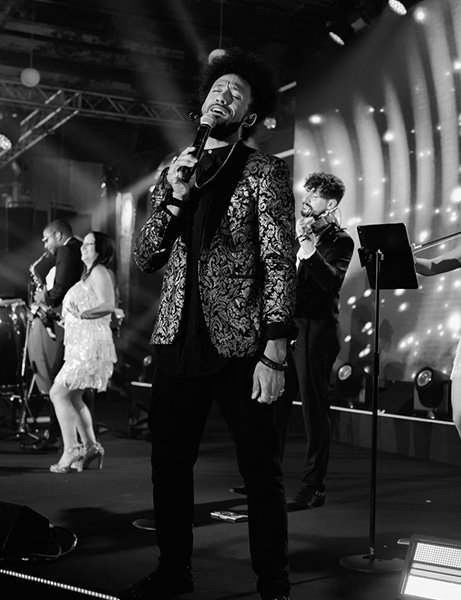 Music artist performing on stage with a microphone at a party